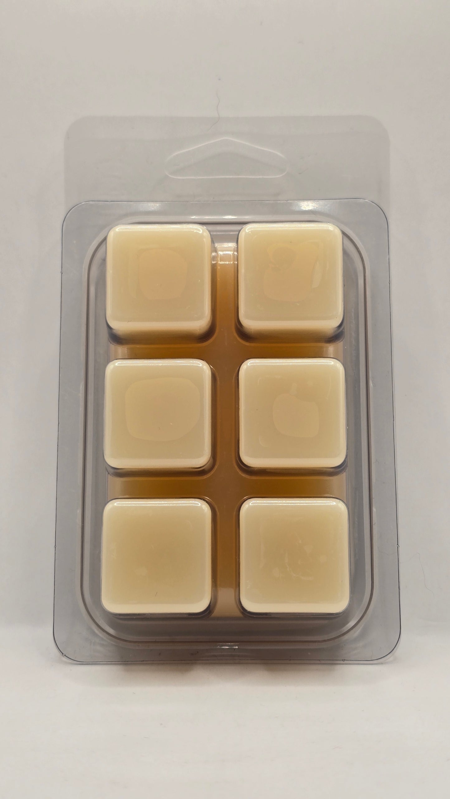Back view of California Poppy Wax Melt clamshell packaging by CORGI CANDLE. Clear plastic wax melt container showing soy wax cubes with black and white label visible through the back.