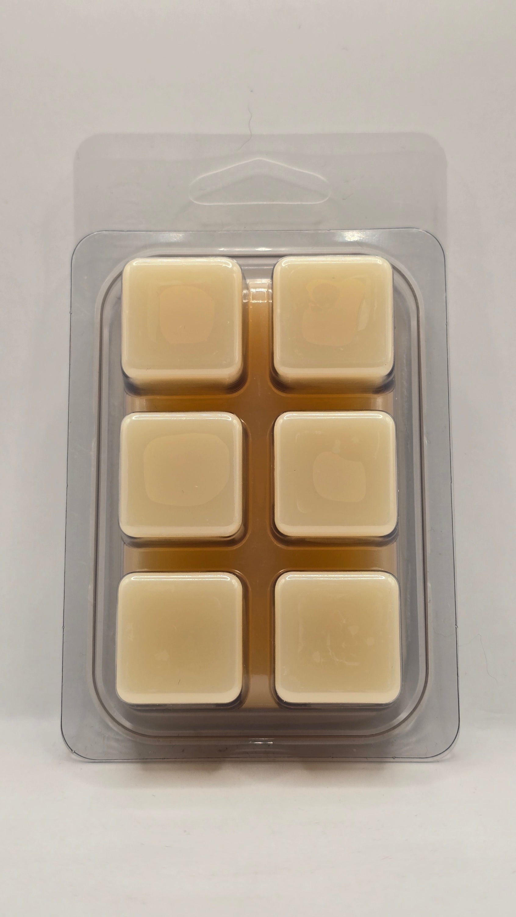 Back view of California Poppy Wax Melt clamshell packaging by CORGI CANDLE. Clear plastic wax melt container showing soy wax cubes with black and white label visible through the back.