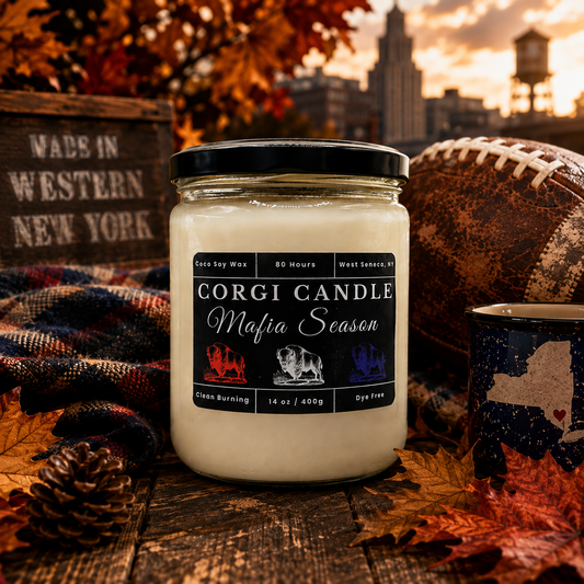 CORGI CANDLE Mafia Season 14 oz coco soy wax candle on a rustic wooden table with autumn leaves, buffalo plaid blanket, vintage football, and Western New York inspired fall décor.