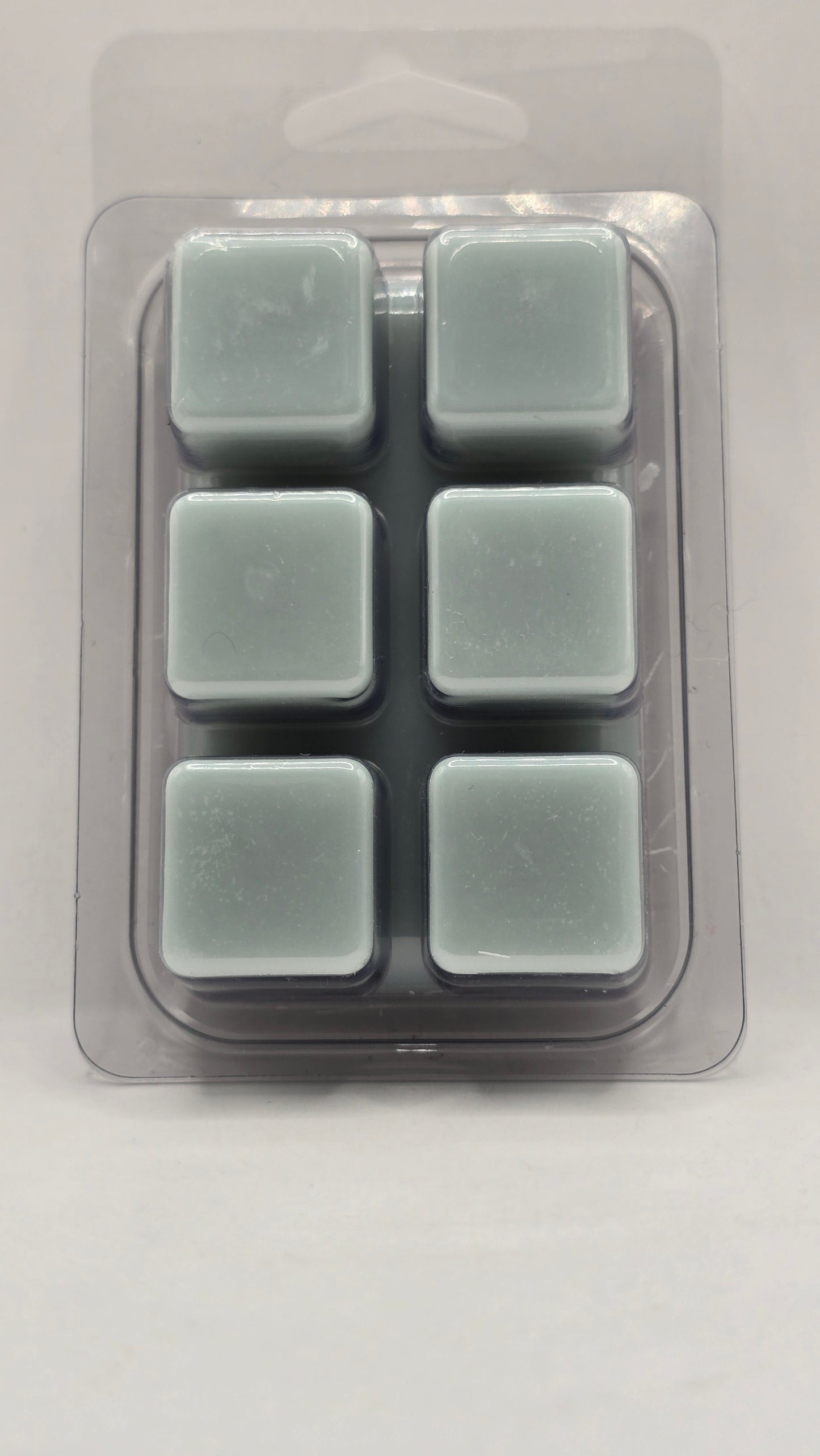Back of Mineral Springs soy wax melt showing six light blue wax cubes inside clear plastic clamshell packaging.