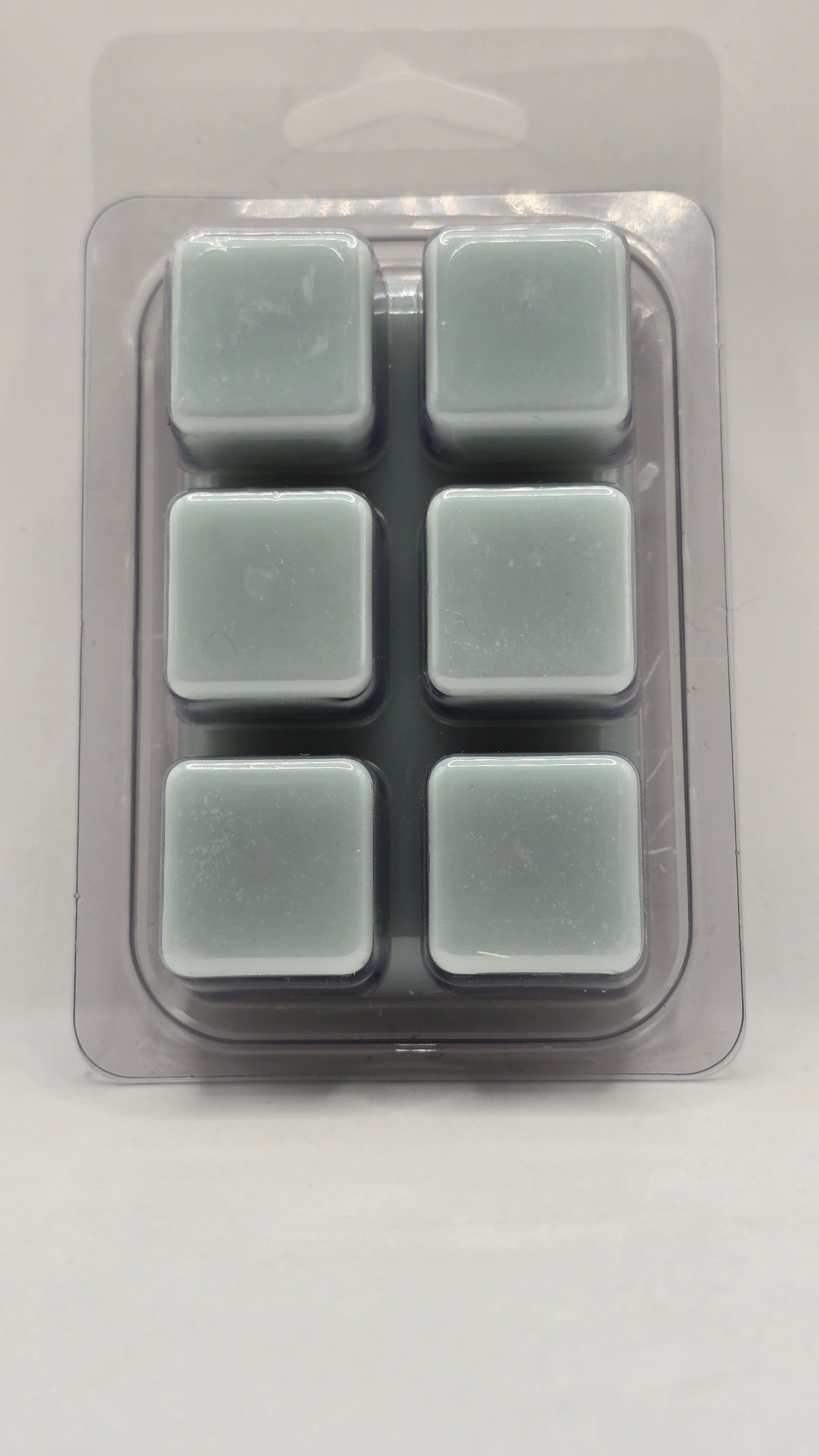 Back of Mineral Springs soy wax melt showing six light blue wax cubes inside clear plastic clamshell packaging.