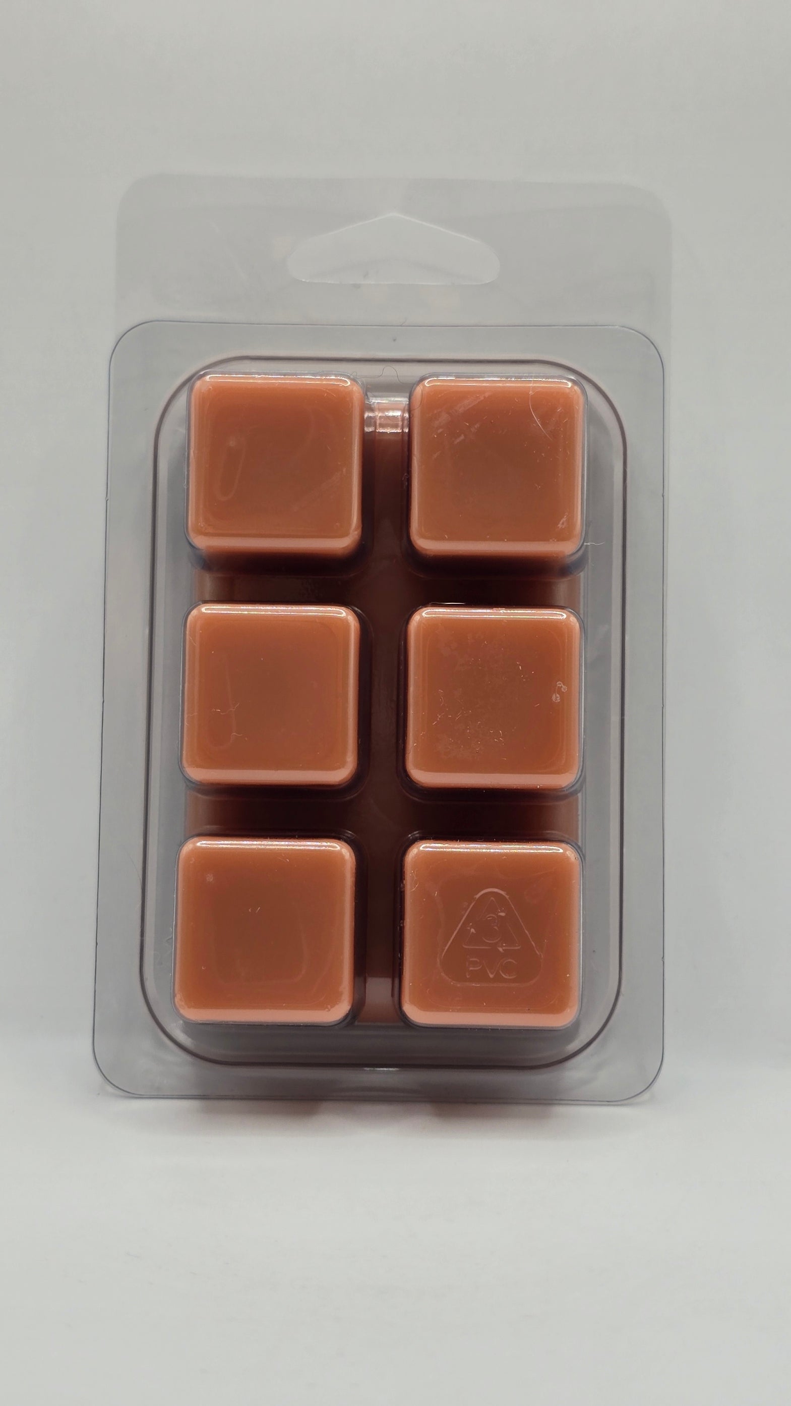 Packaged brown wax melts on a light gray background