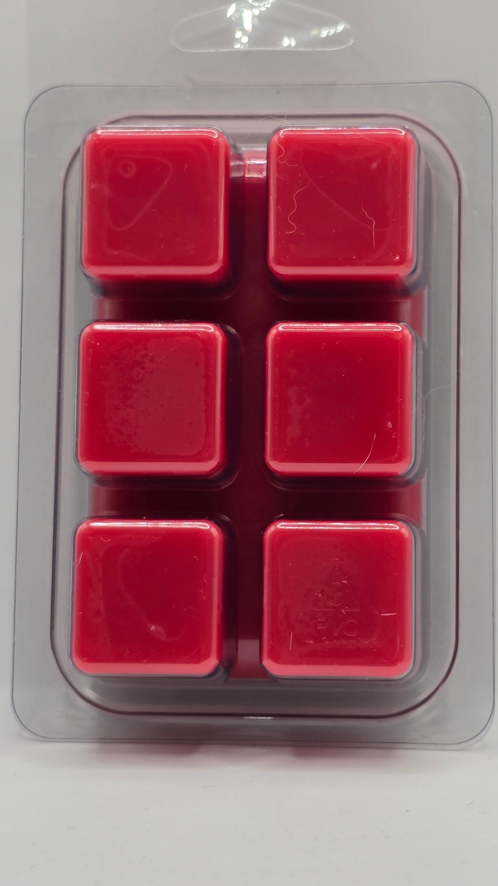 Red square wax melts in a clear plastic packaging on a light gray background