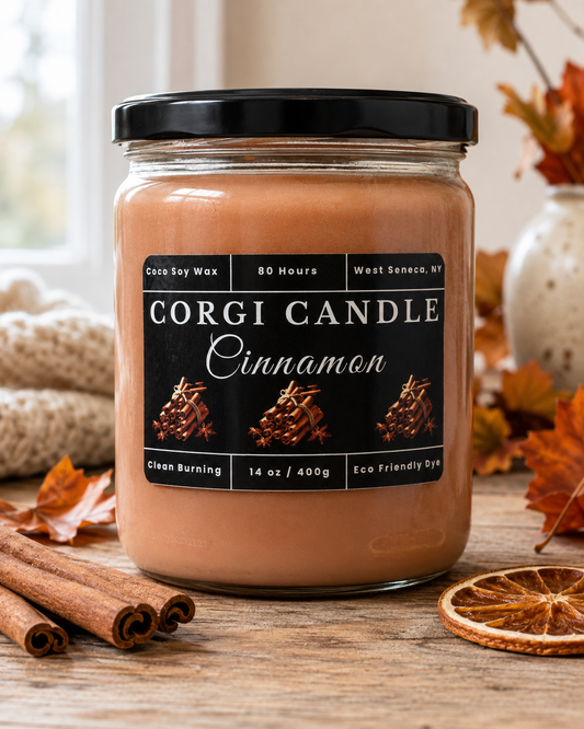 CORGI CANDLE 14 oz Cinnamon soy and coconut wax candle on a rustic wood surface with cinnamon sticks, dried orange and autumn leaves.