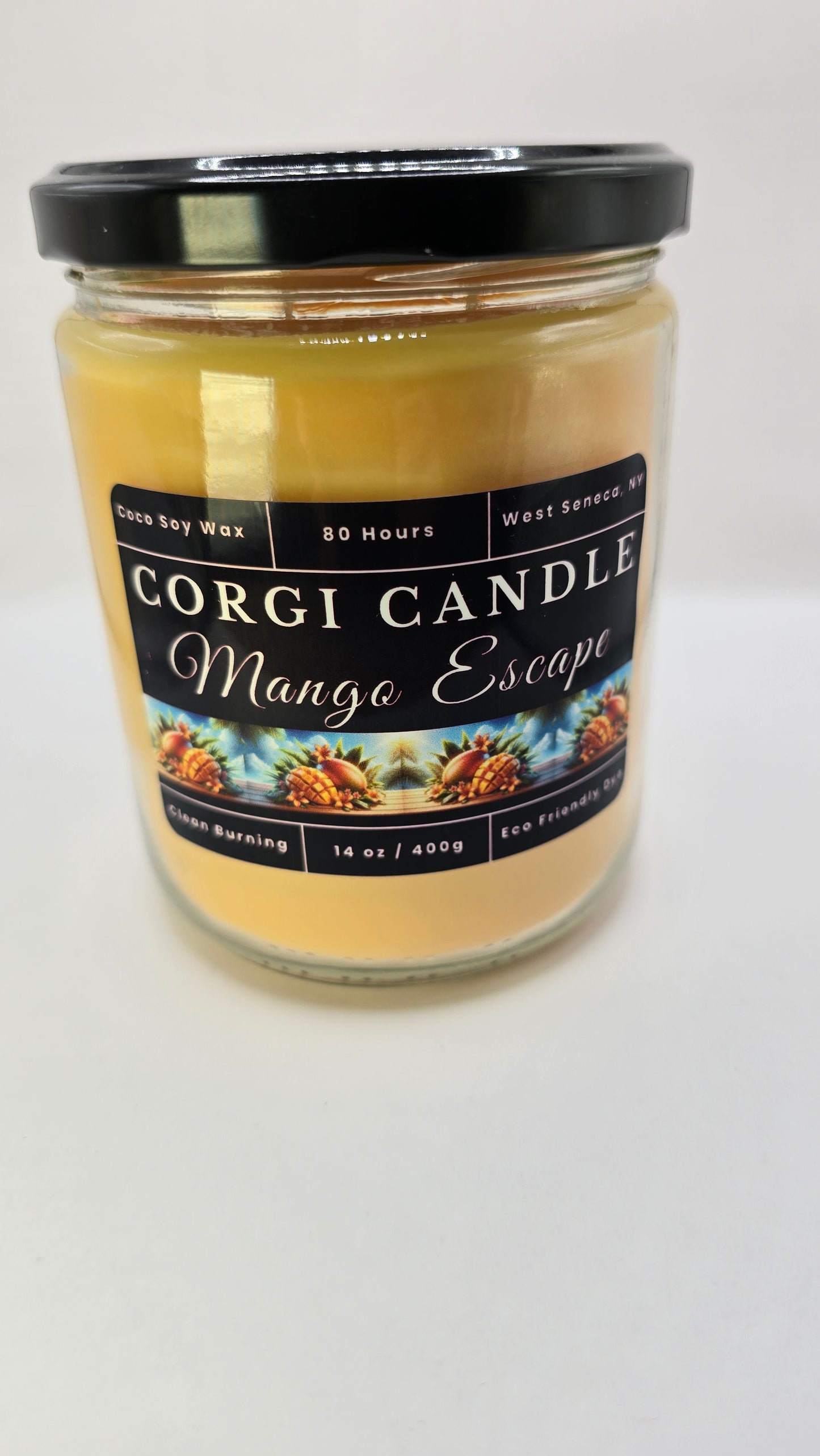 Corgi Candle Mango Escape 14 oz soy candle in a clear glass jar with a minimalist tropical label, featuring a sweet mango, coconut, and pineapple scent