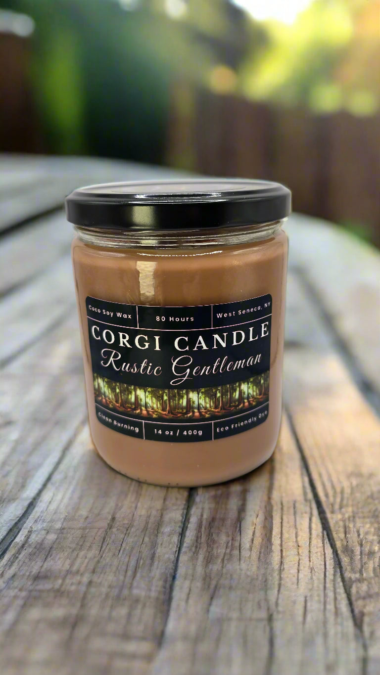 Rustic Gentleman 14 oz soy candle by CORGI CANDLE in a sleek glass jar with a masculine label, featuring teakwood, oak, and cedar notes.
